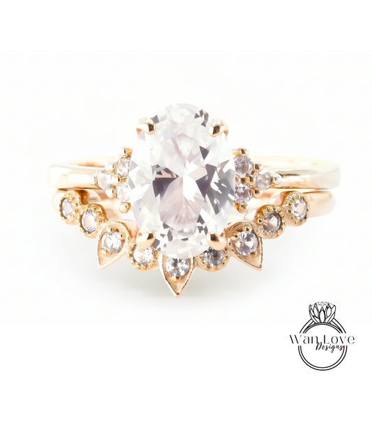 A gold ring with a large oval-shaped gemstone, surrounded by smaller diamonds and pearls.