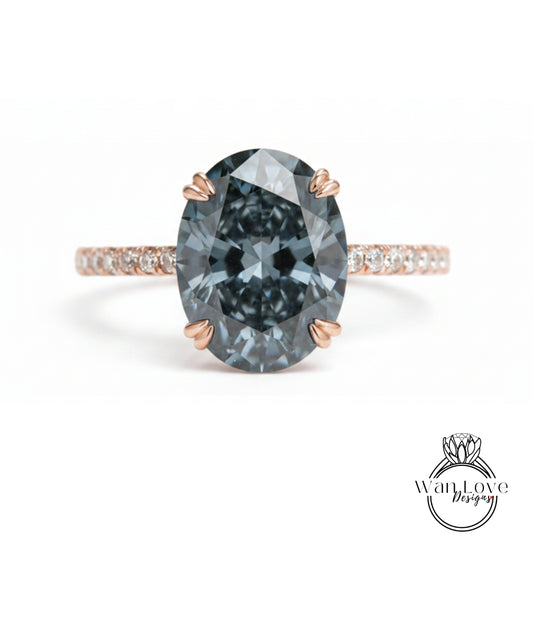 A close-up of a large, dark blue diamond ring with a rose gold band and small diamonds around the band.