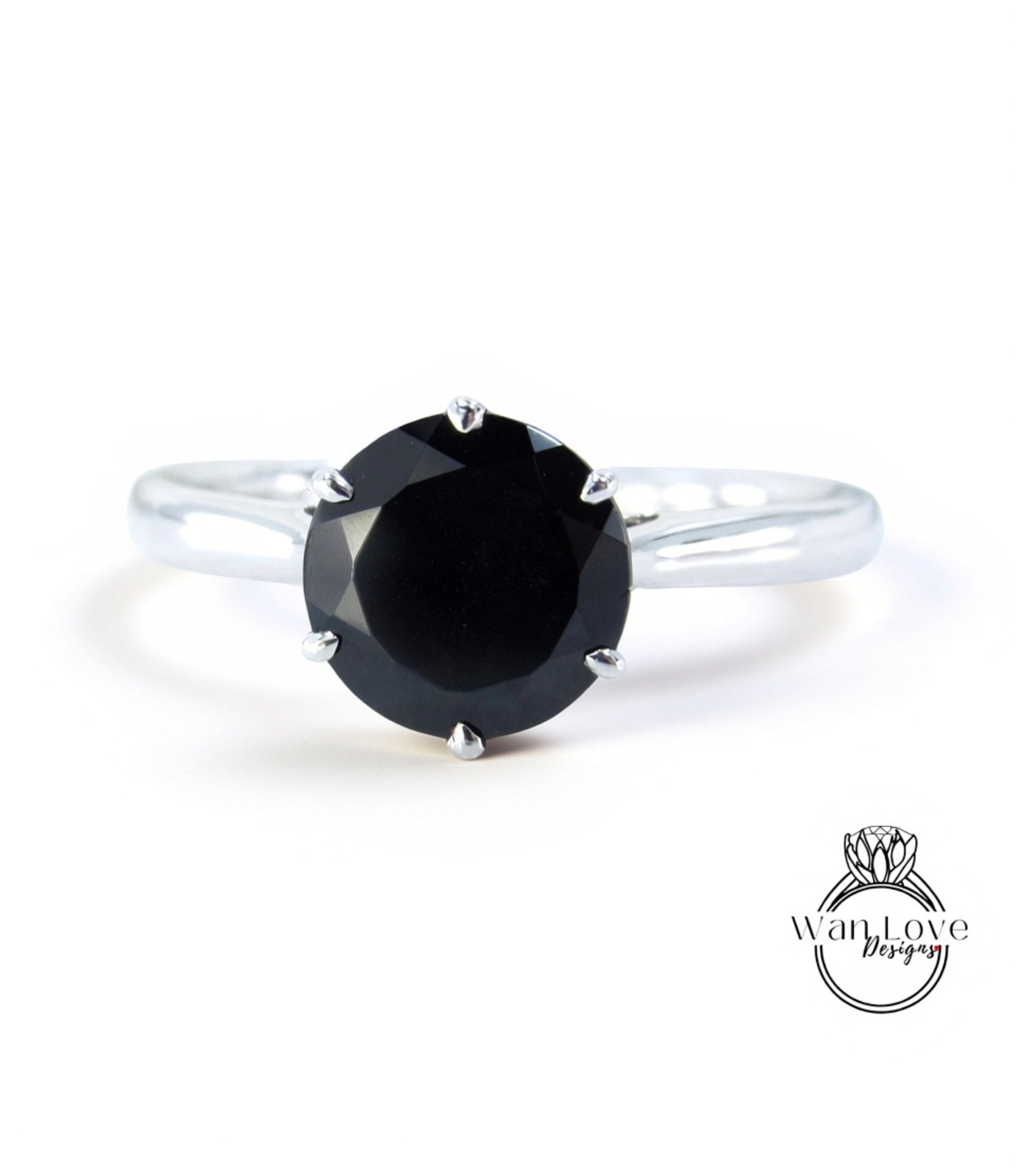 A silver ring with a large black diamond as the centerpiece.