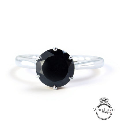 A silver ring with a large black diamond as the centerpiece.