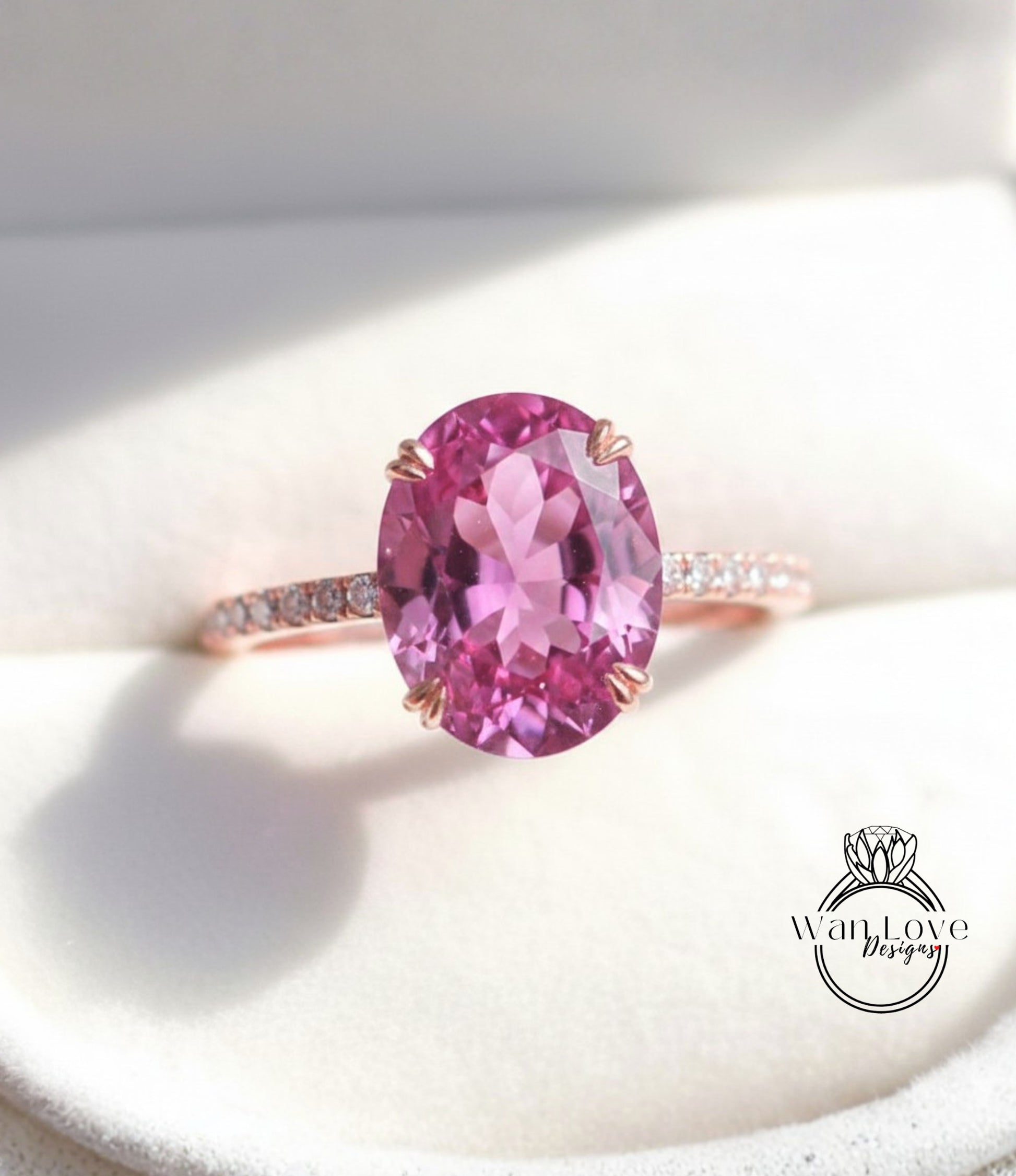 A close-up image of a pink gemstone ring with a large oval-shaped gemstone set in a rose gold band.