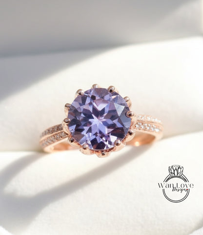 A close-up image of a rose gold ring with a large, round purple gemstone set in the center.