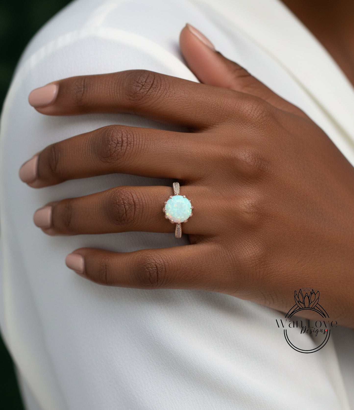 A close-up of a hand wearing a ring with a large, round opal stone.