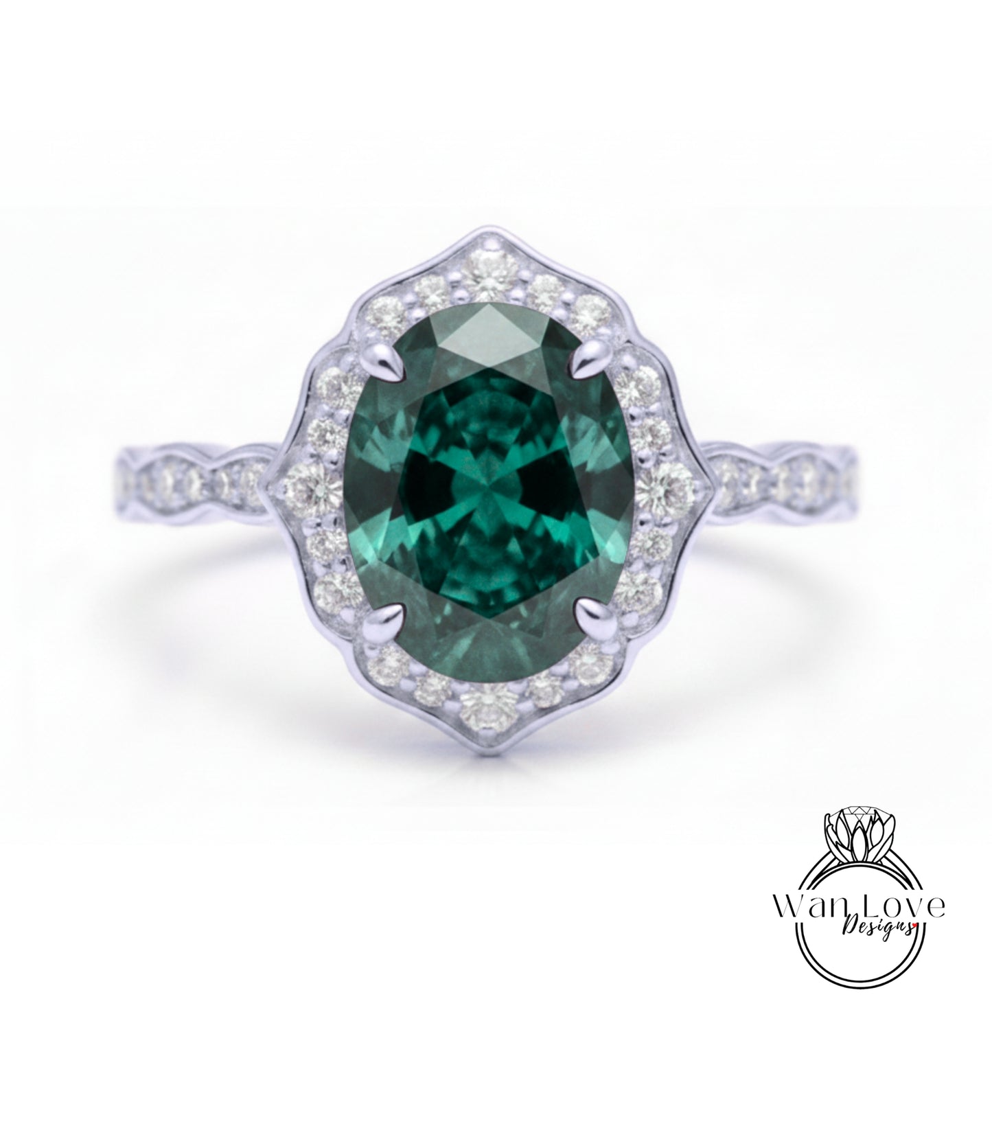 A stunning engagement ring with a large oval-shaped green gemstone set in a halo of smaller diamonds, surrounded by a scalloped edge.