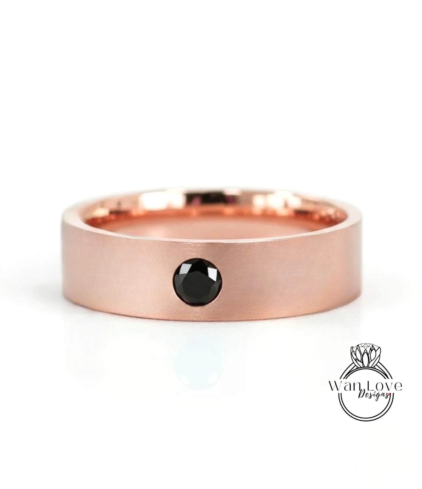A rose gold band with a black gemstone set in the center.