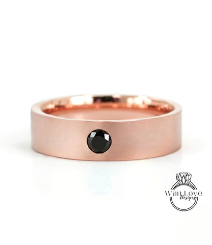 A rose gold band with a black gemstone set in the center.