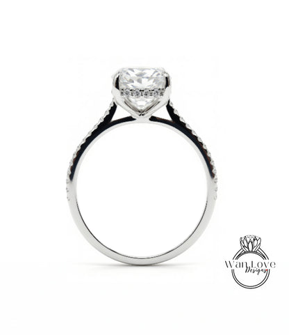 A close-up view of a silver engagement ring with a large, clear gemstone set in the center.