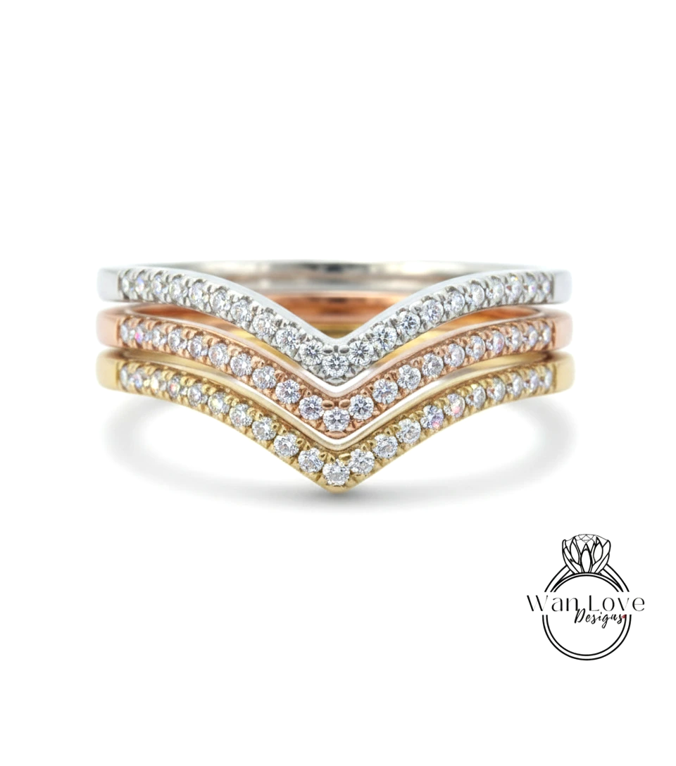 A ring with a diamond band featuring three different colored diamonds arranged in a v-shape.