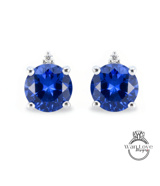 A pair of earrings with blue gemstones, possibly sapphires, set in silver.