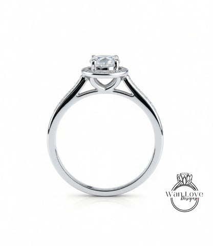 A silver engagement ring with a large central diamond and smaller diamonds on either side of the halo.