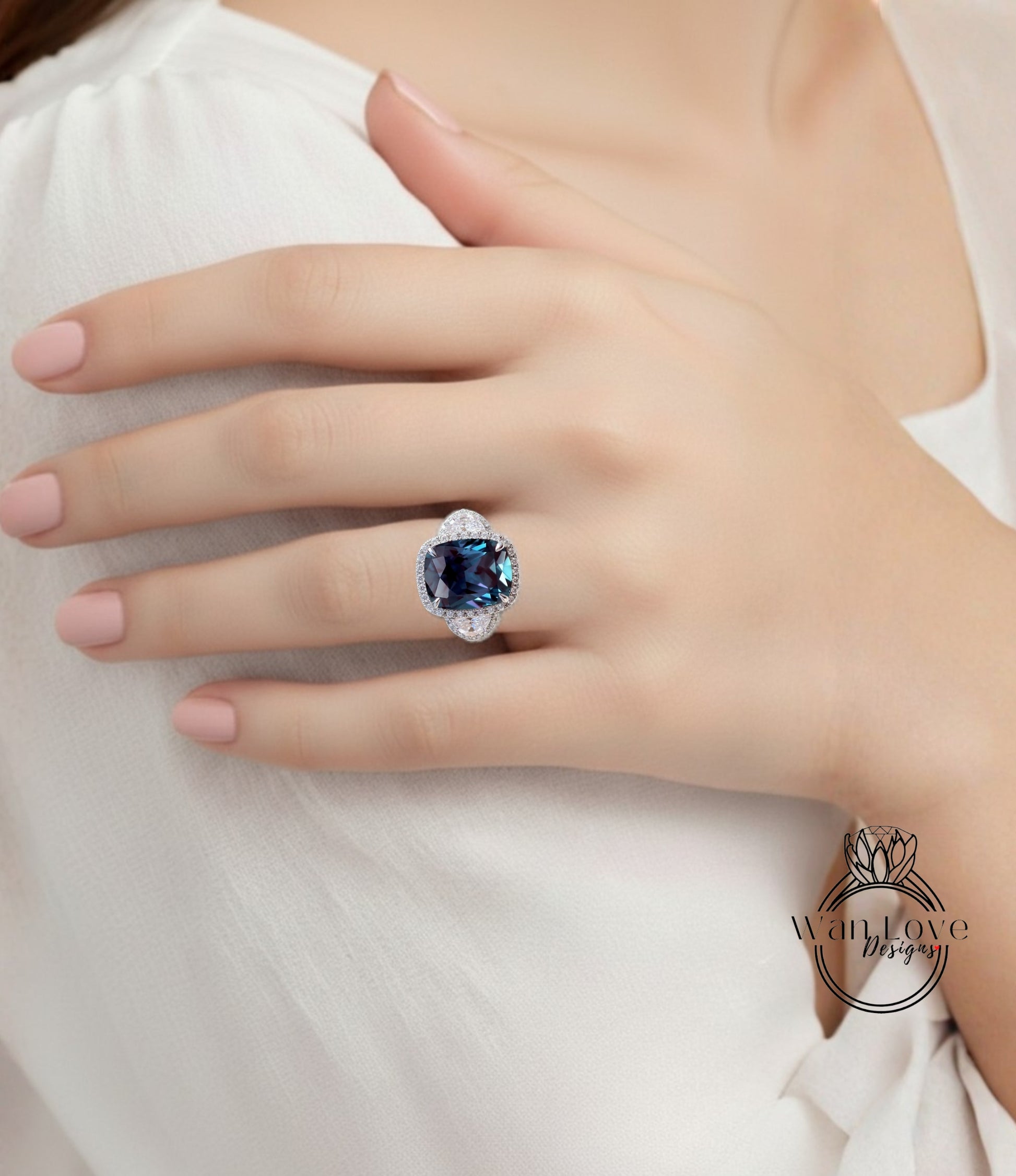 A close-up of a person's hand wearing a large, blue gemstone ring on the ring finger.