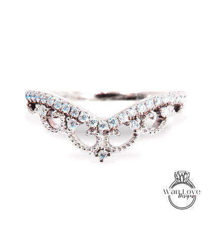 A close-up view of a diamond ring with a decorative band featuring a floral design.