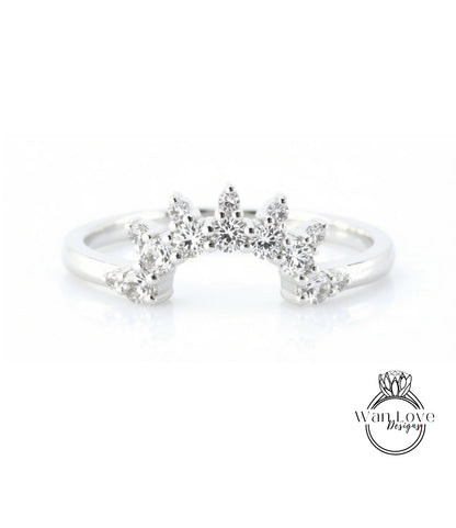 A silver ring with a large, sparkling diamond center stone surrounded by smaller diamonds, creating a radiant and elegant design.
