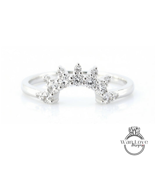 A silver ring with a large, sparkling diamond center stone surrounded by smaller diamonds, creating a radiant and elegant design.
