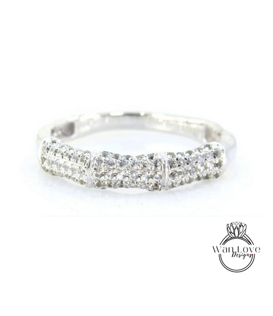A silver ring with a row of small diamonds set in it.