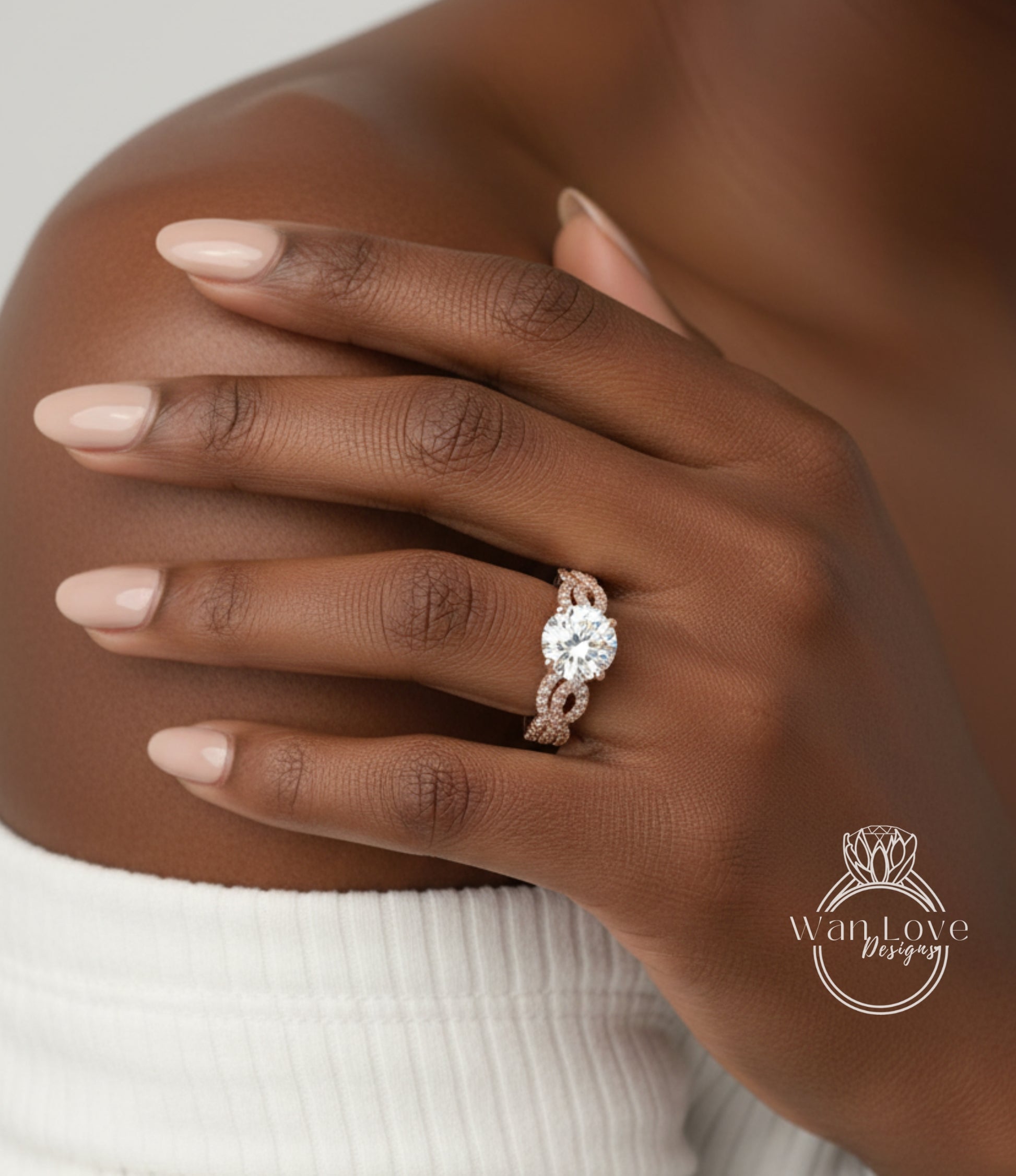 A close-up of a person's hand wearing a diamond engagement ring on the ring finger.