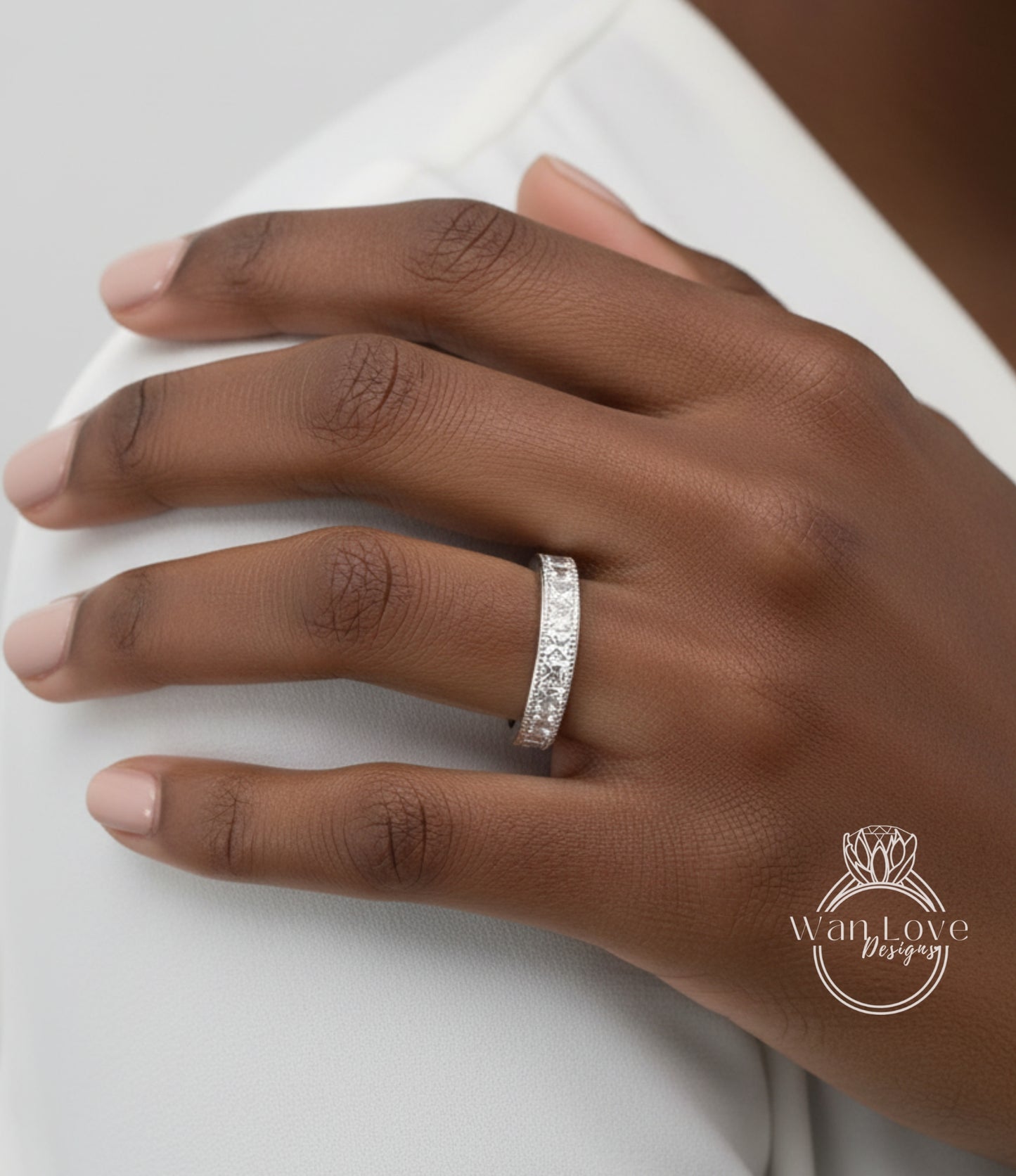 A close-up of a person's hand wearing a diamond ring on the ring finger.