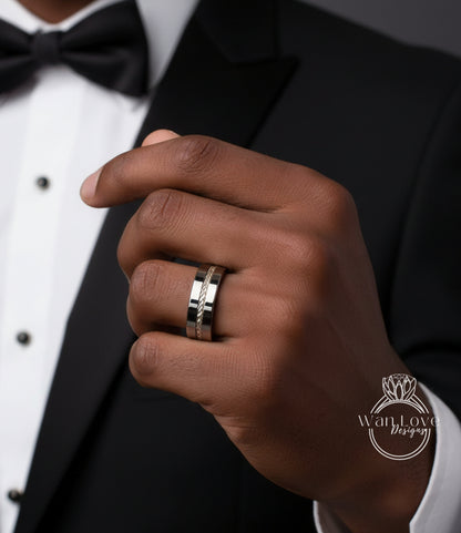 A close-up of a person's hand wearing a silver wedding ring, with a black tuxedo jacket visible in the background.