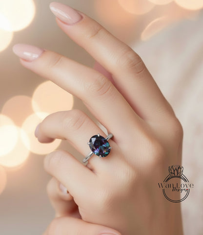 A close-up of a hand wearing a ring with a large, dark blue gemstone.
