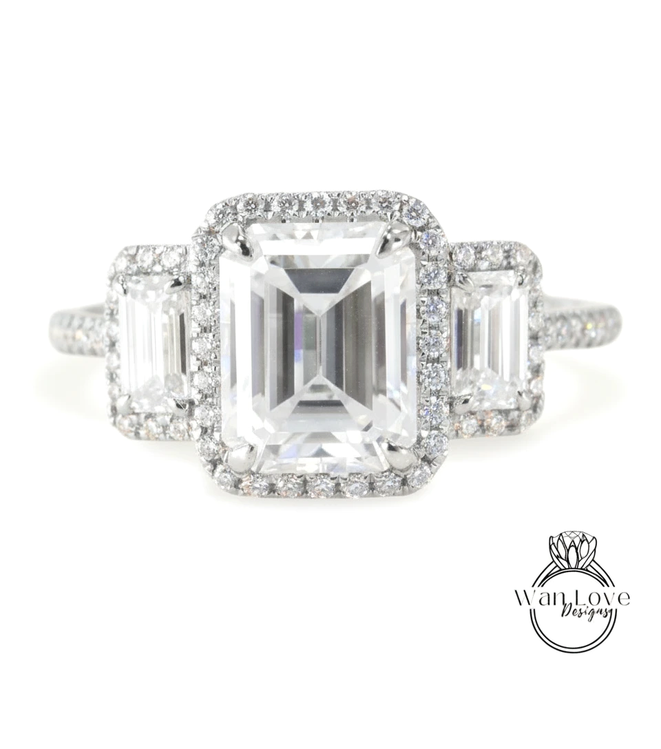 A close-up of a diamond engagement ring with a large central diamond surrounded by smaller diamonds on either side.