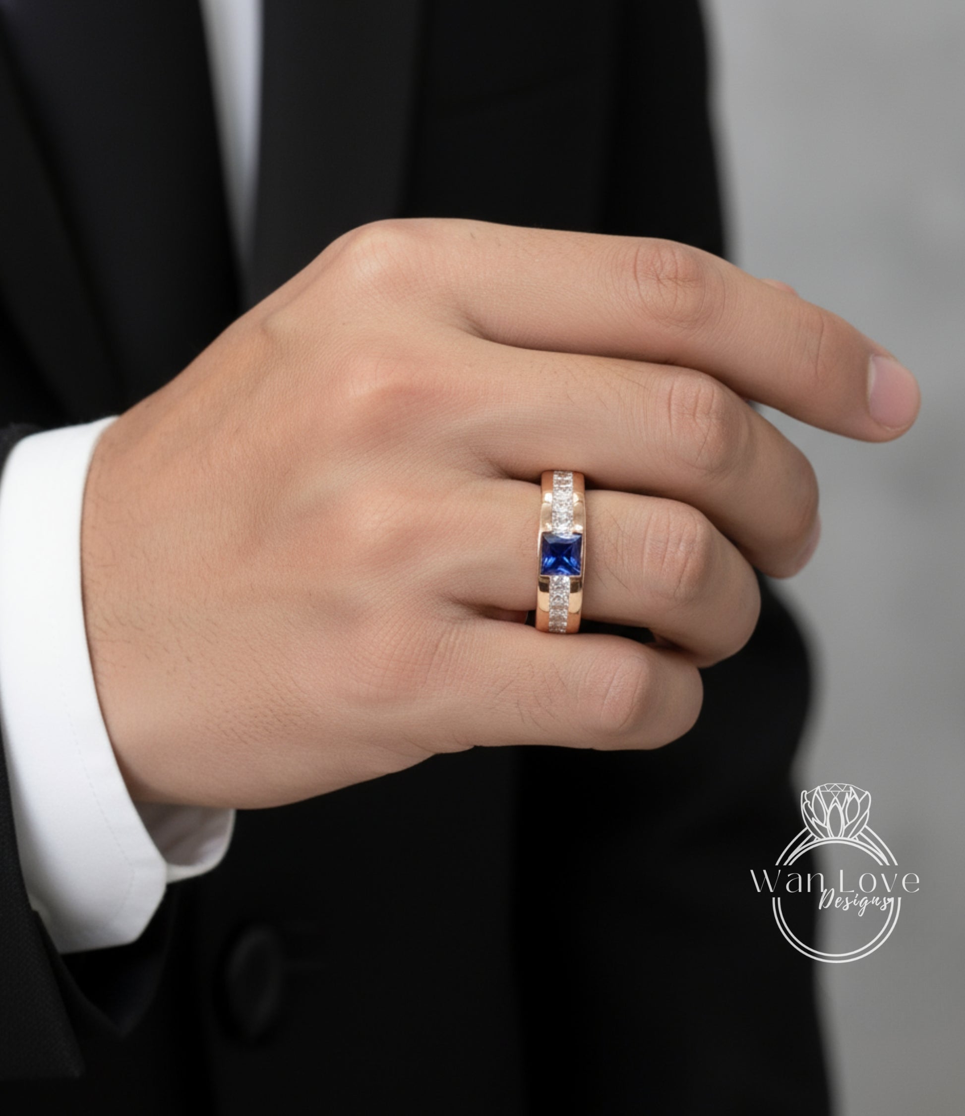 A close-up of a person's hand wearing a gold ring with a blue gemstone.