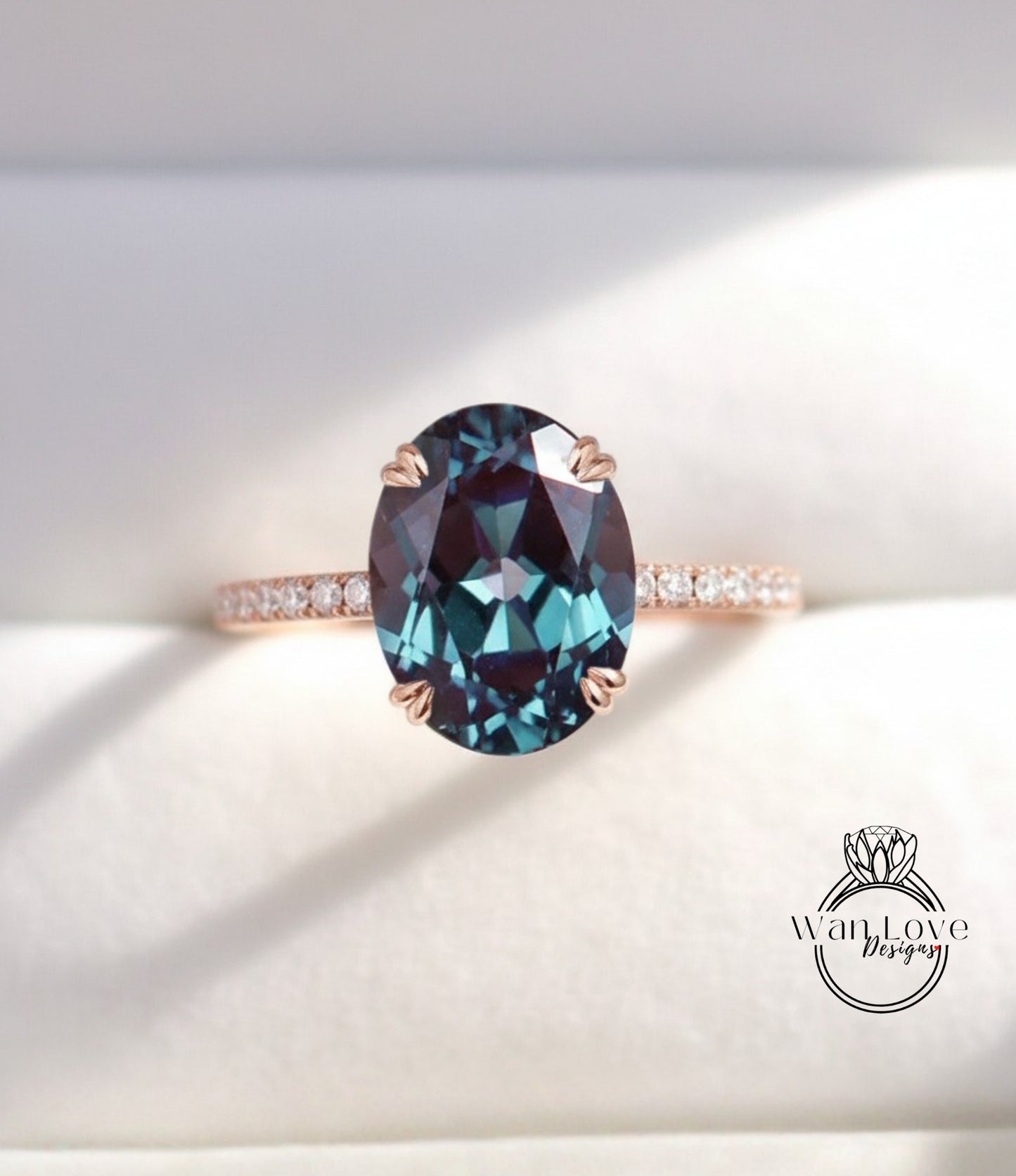 A close-up image of a rose gold ring with a large oval-shaped blue gemstone set in the center.