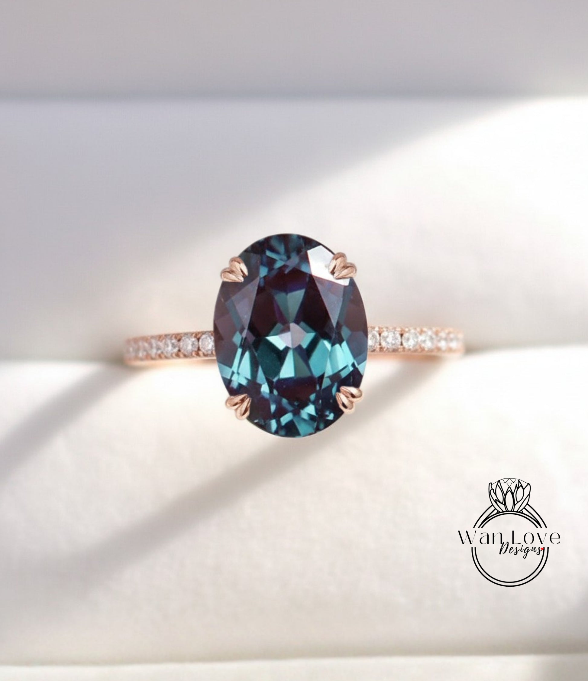 A close-up image of a rose gold ring with a large oval-shaped blue gemstone set in the center.