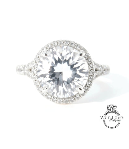 A large, clear diamond ring with a halo of smaller diamonds around the center stone.
