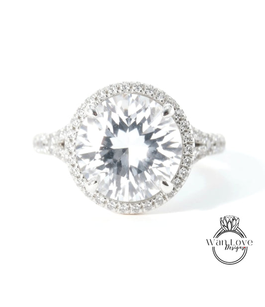 A large, clear diamond ring with a halo of smaller diamonds around the center stone.
