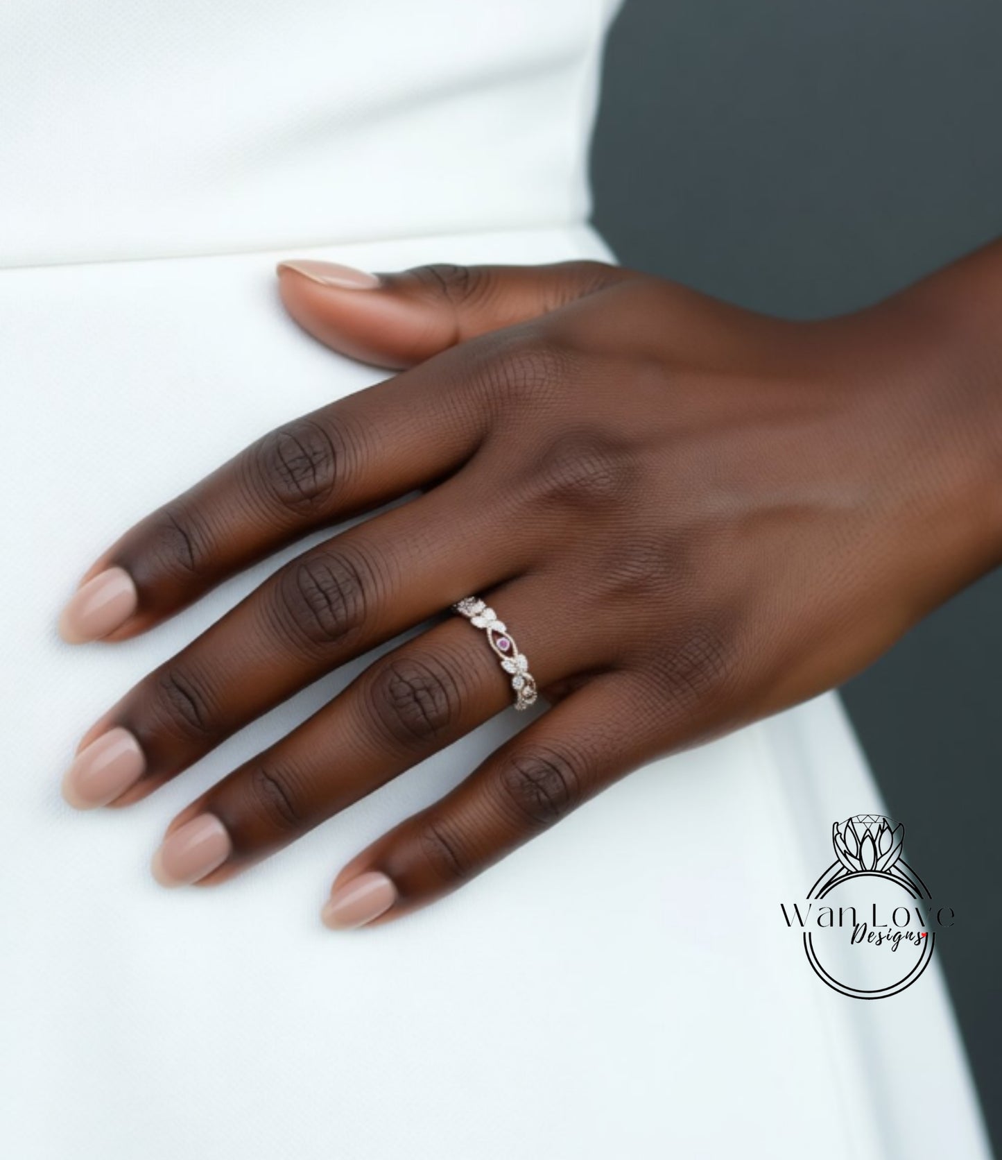 A close-up of a hand wearing a ring on the ring finger.