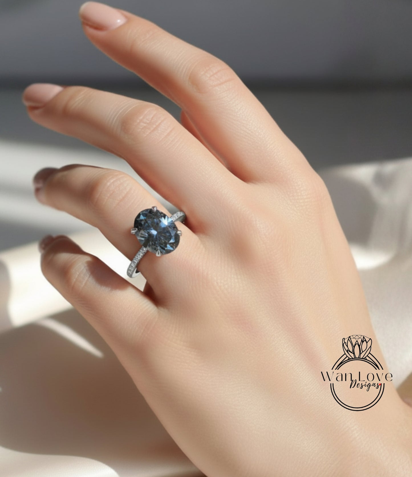 A close-up of a hand wearing a large blue gemstone ring with a diamond band.