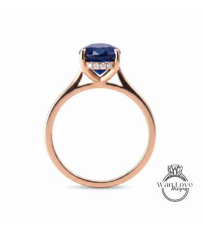 A rose gold engagement ring with a large blue gemstone set in the center.