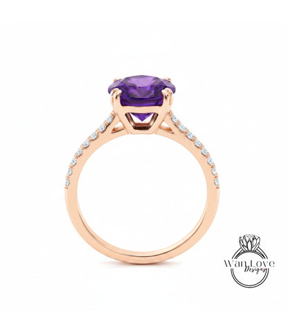 A gold ring with a large purple gemstone set in the center, surrounded by smaller diamonds along the band.