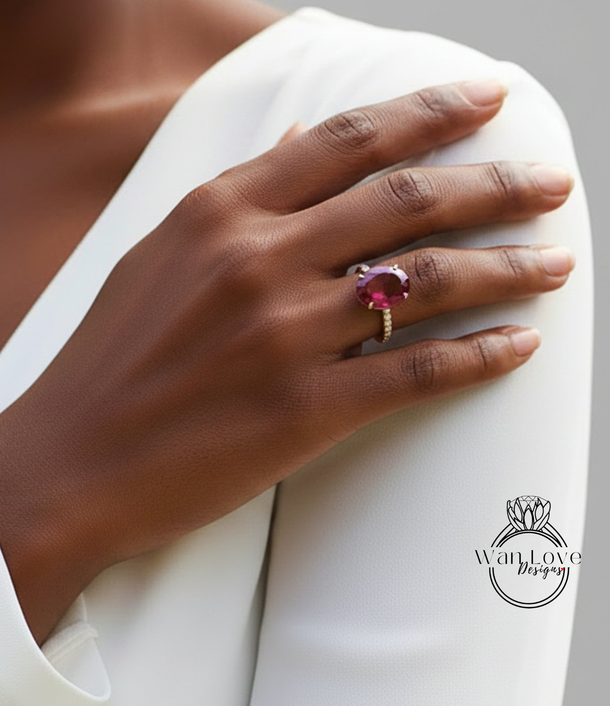 A close-up of a person's hand wearing a large, vibrant pink gemstone ring on the ring finger.