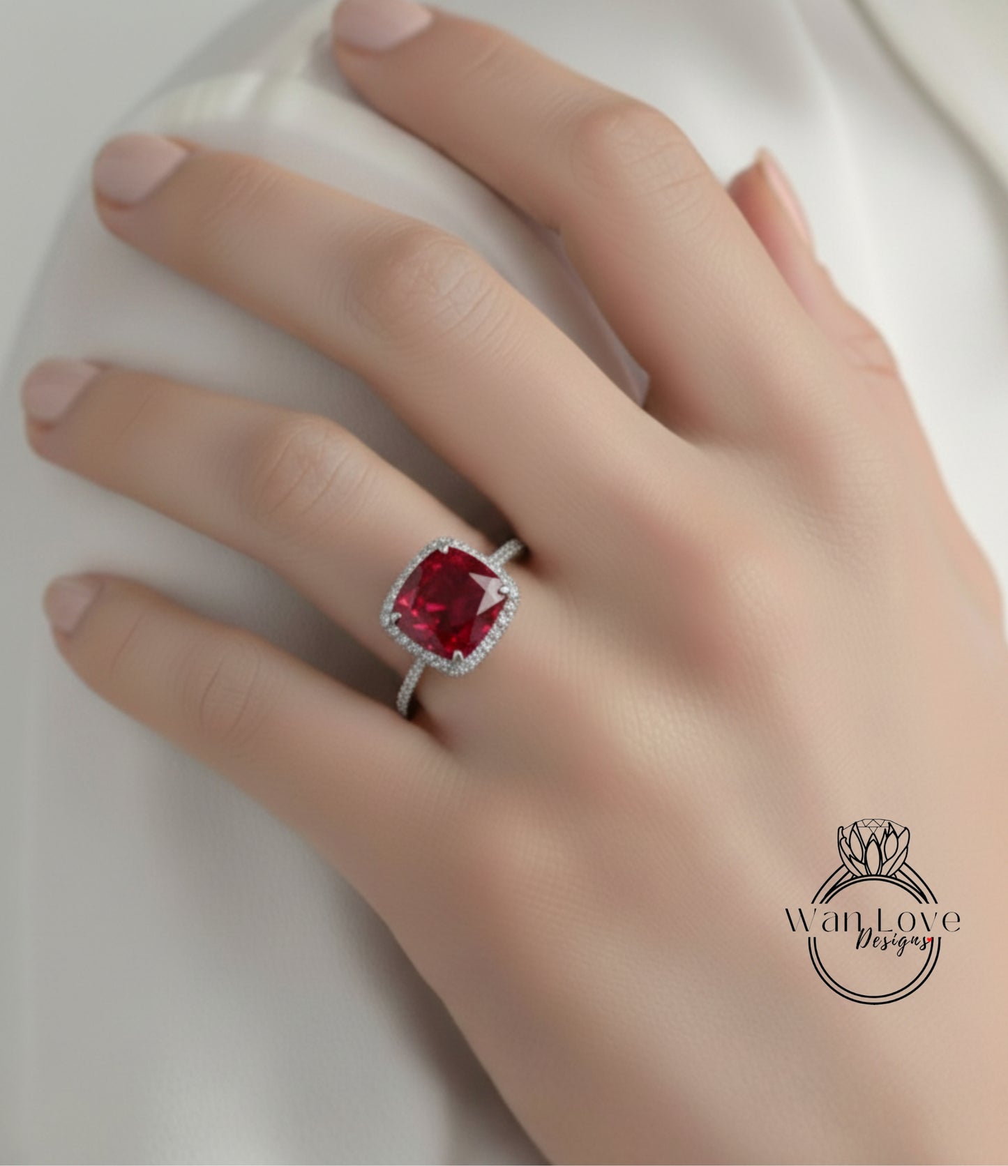 A close-up of a person's hand wearing a ring with a large, vibrant red gemstone.