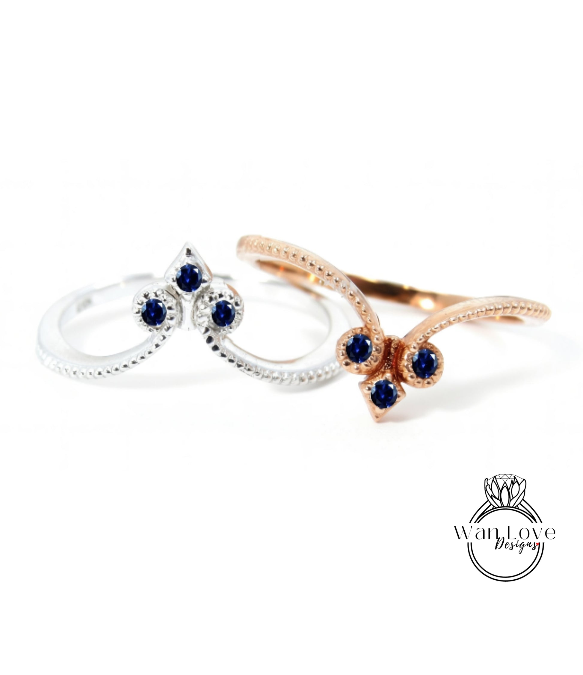 two rings with blue gemstones, one silver and one gold, set against a white background.