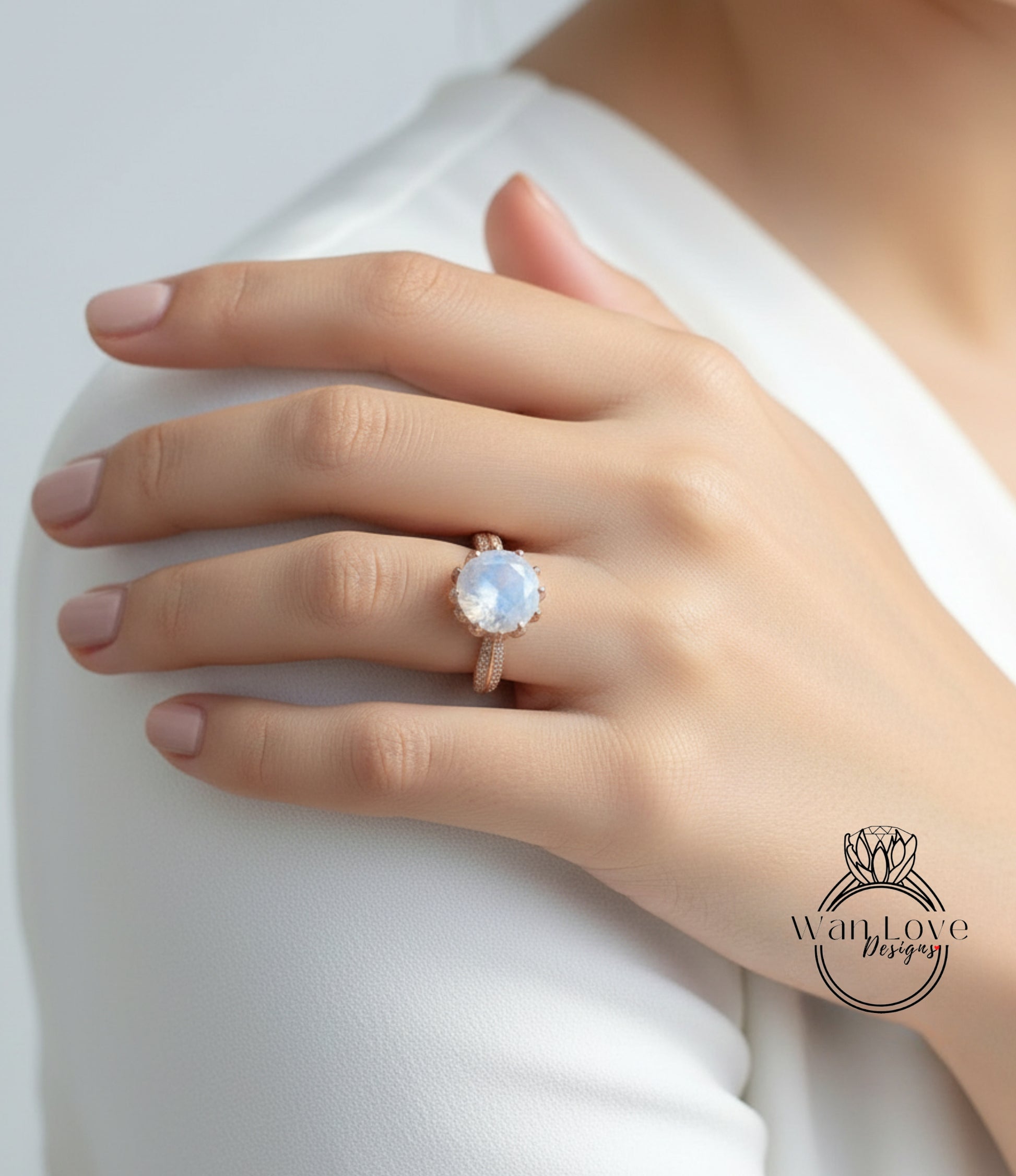 A close-up of a person's hand wearing a large, round, blue gemstone ring on the ring finger.
