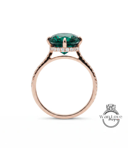 A rose gold ring with a large, green gemstone set in the center.