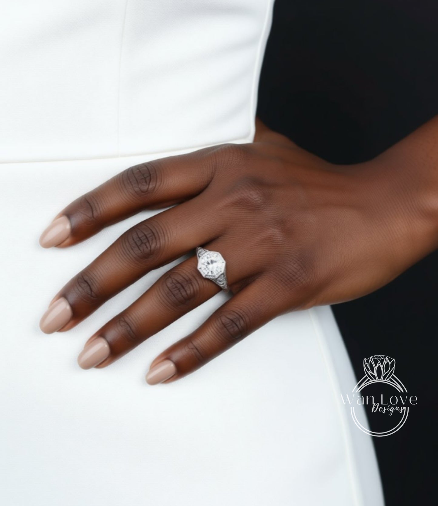 A close-up of a hand wearing a diamond engagement ring on the ring finger.