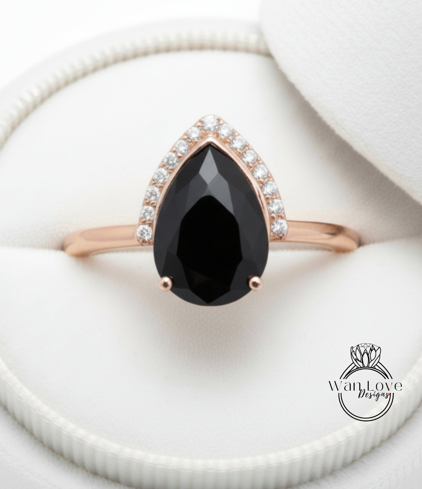 A close-up image of a gold ring with a large black gemstone, likely a diamond, set in the center of the band.