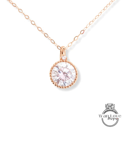 A delicate rose gold necklace with a large, round, clear gemstone pendant.