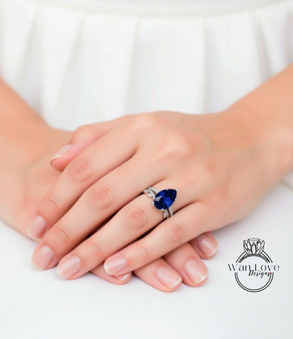A close-up image of a person's hands wearing a ring with a large blue gemstone.