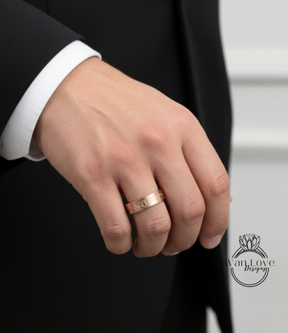 A close-up of a person's hand wearing a gold ring, with a black suit jacket visible in the background.