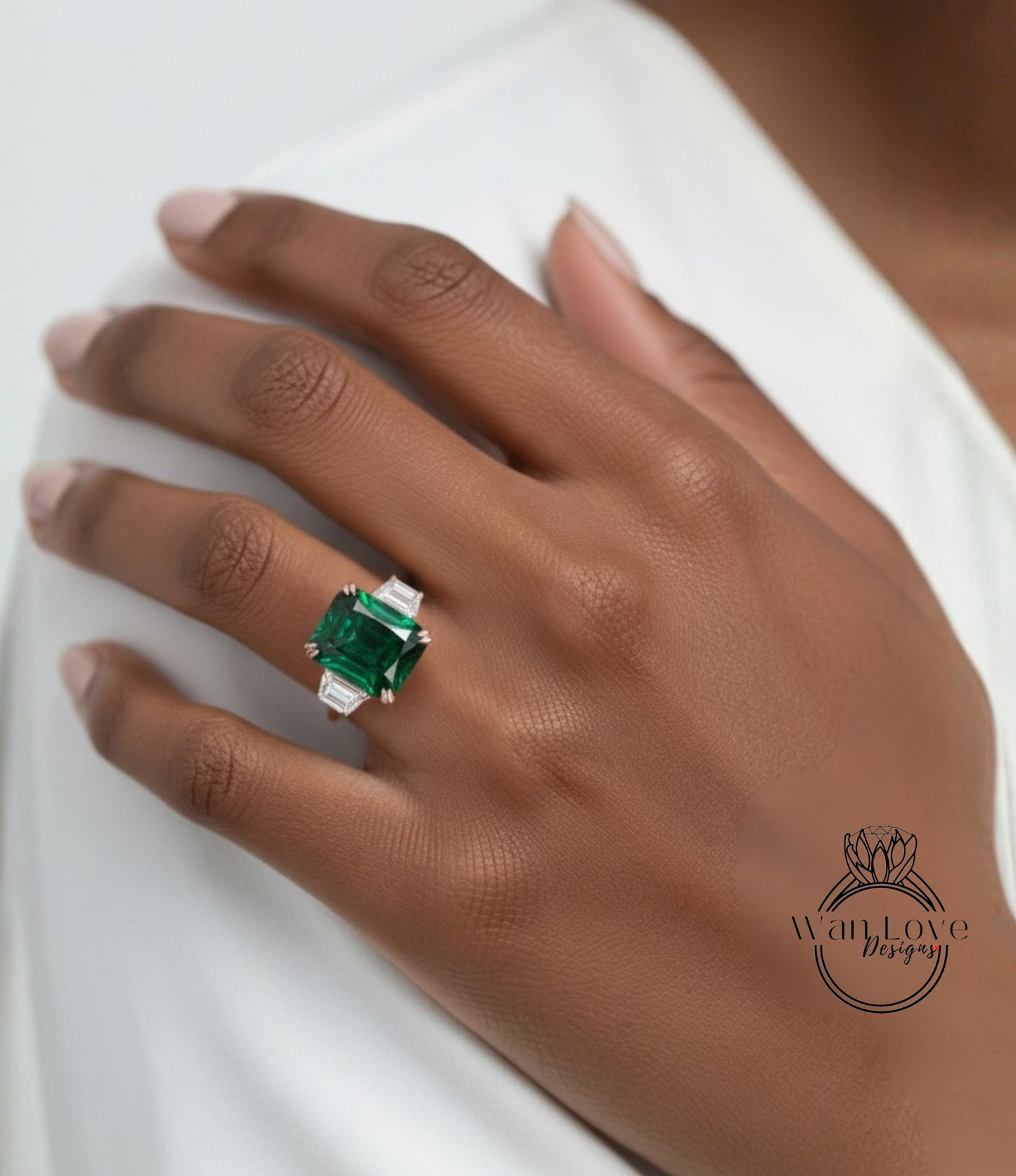 A close-up of a person's hand wearing a large, green gemstone ring.