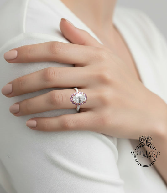 A close-up of a person's hand wearing a large, ornate ring with a large central gemstone surrounded by smaller gemstones.