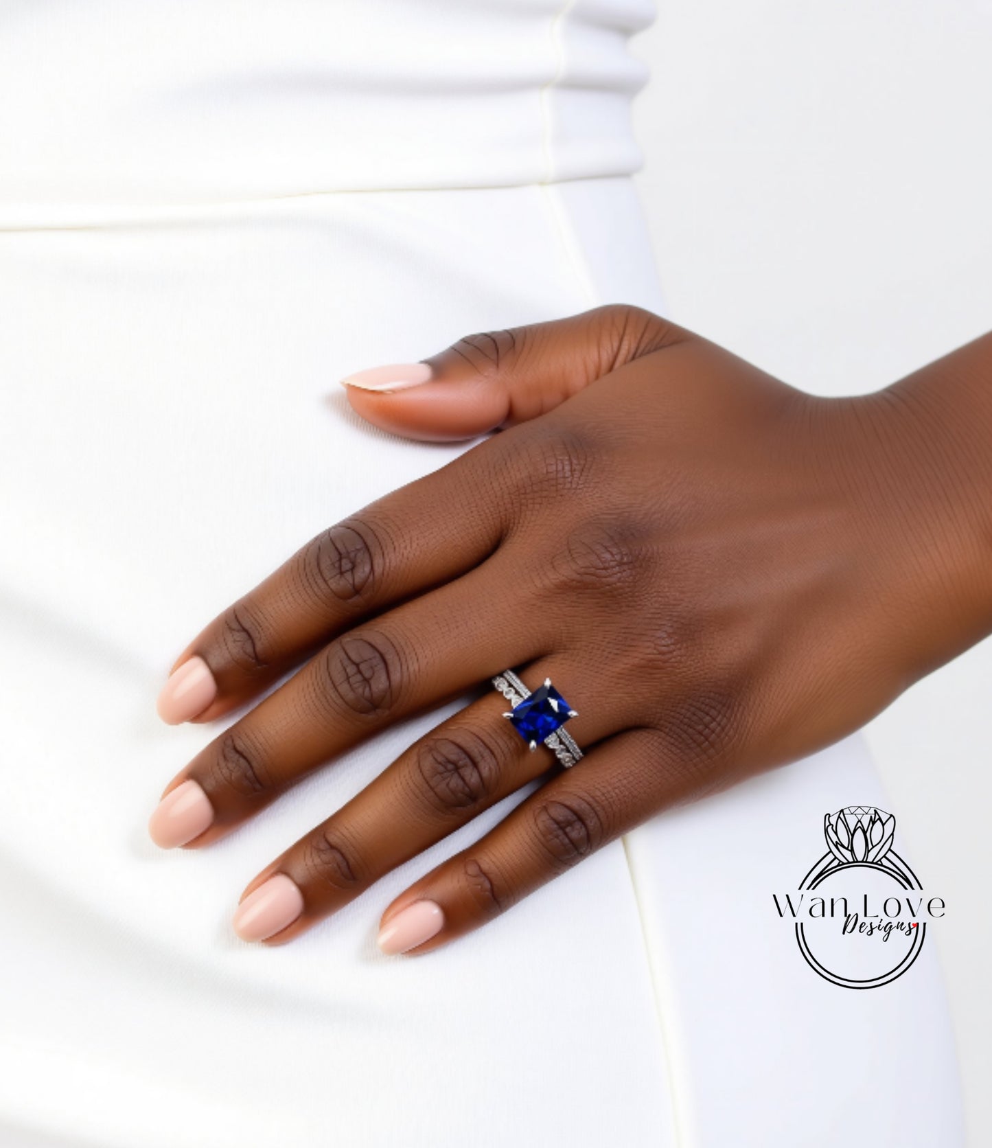 A close-up of a person's hand wearing a ring with a large blue gemstone.