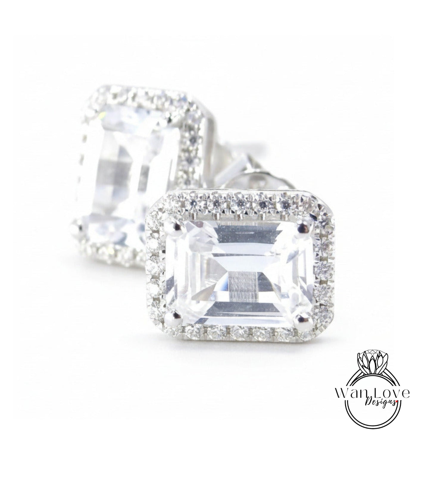 A pair of elegant diamond earrings with a large, clear gemstone set in a halo of smaller diamonds, creating a sparkling and sophisticated appearance.
