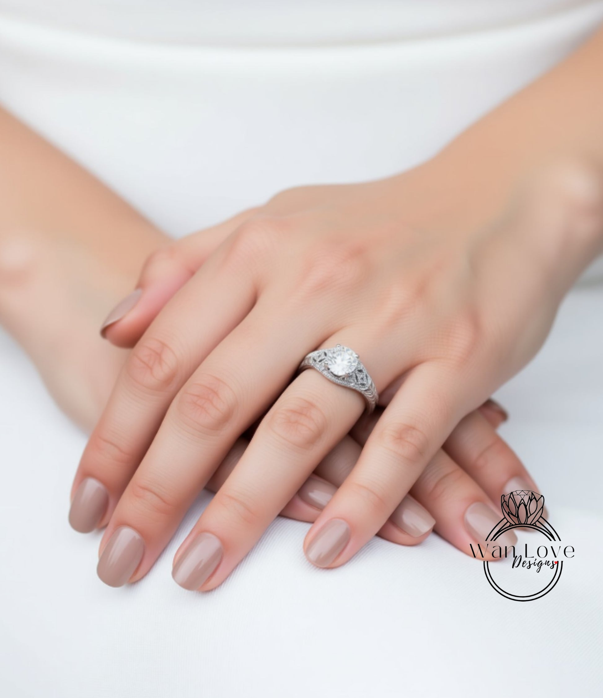 A close-up image of a person's hands with a diamond engagement ring on the ring finger.