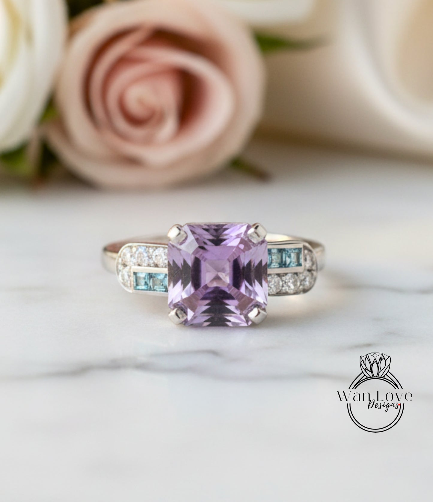 A ring with a large purple gemstone, surrounded by smaller blue gemstones, sits on a marble surface.