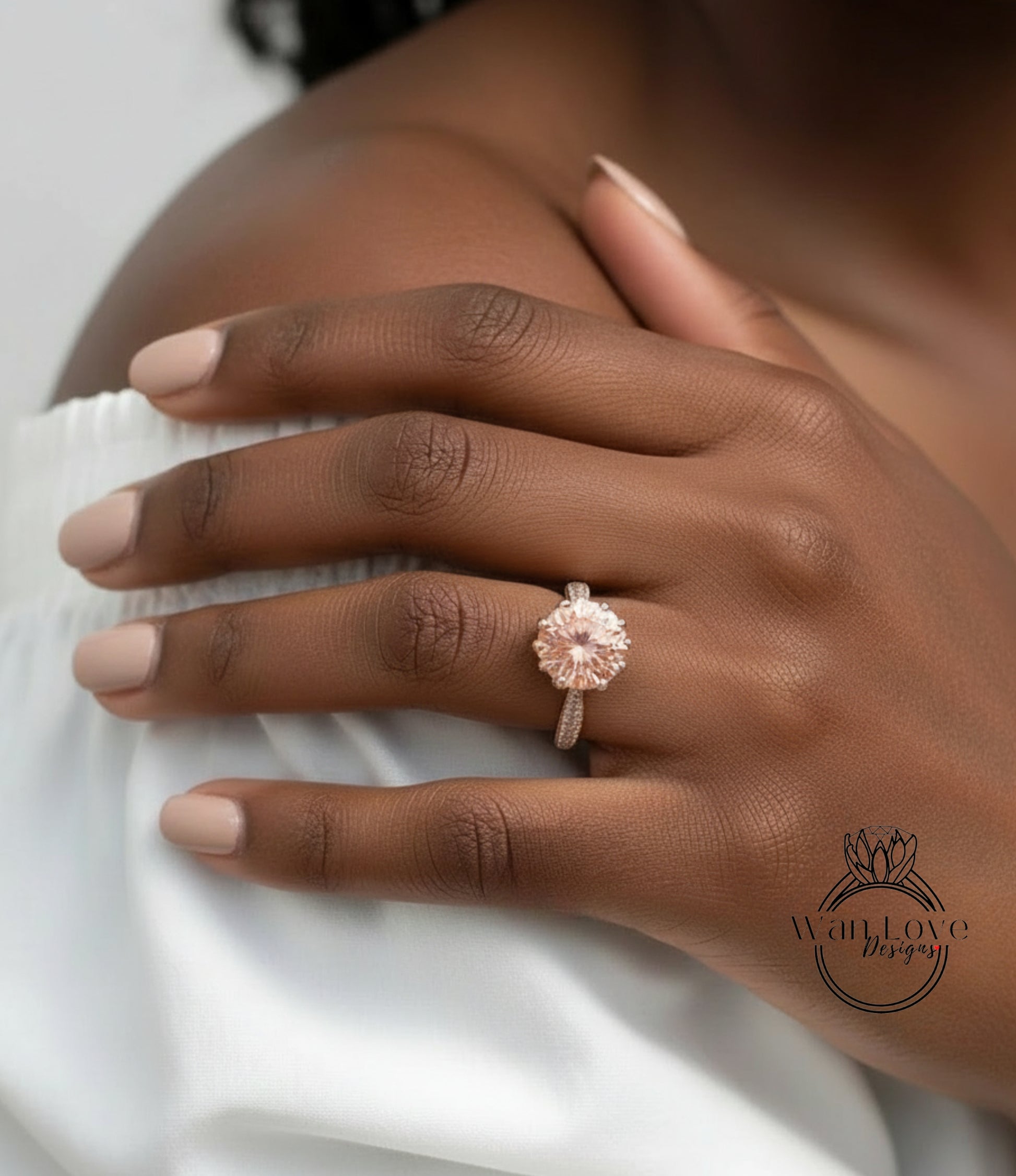 A close-up of a person's hand wearing a large, round, pinkish-colored diamond engagement ring on the ring finger.